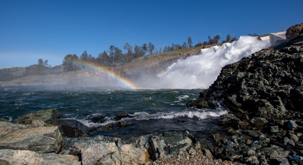 Water being released from Lake Oroville, with a rainbow at the bottom of the flow.